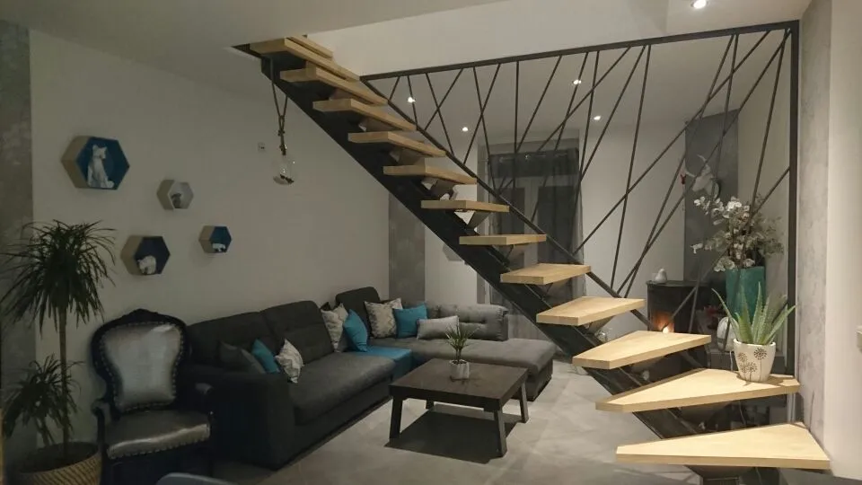 Escalier suspendu en bois avec rambarde en métal.